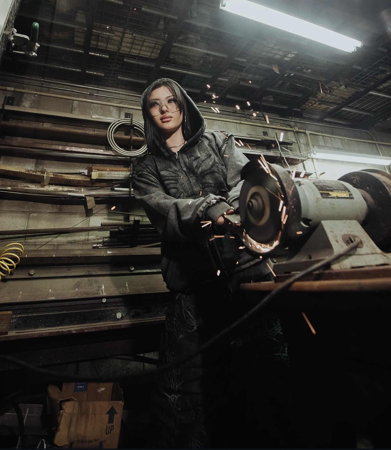 Gothic editorial campaign — workshop scene, hooded model with angle grinder